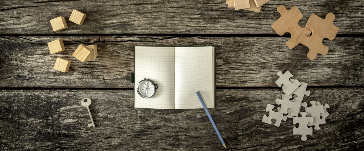 a key and puzzle pieces next to a notepad and a timer