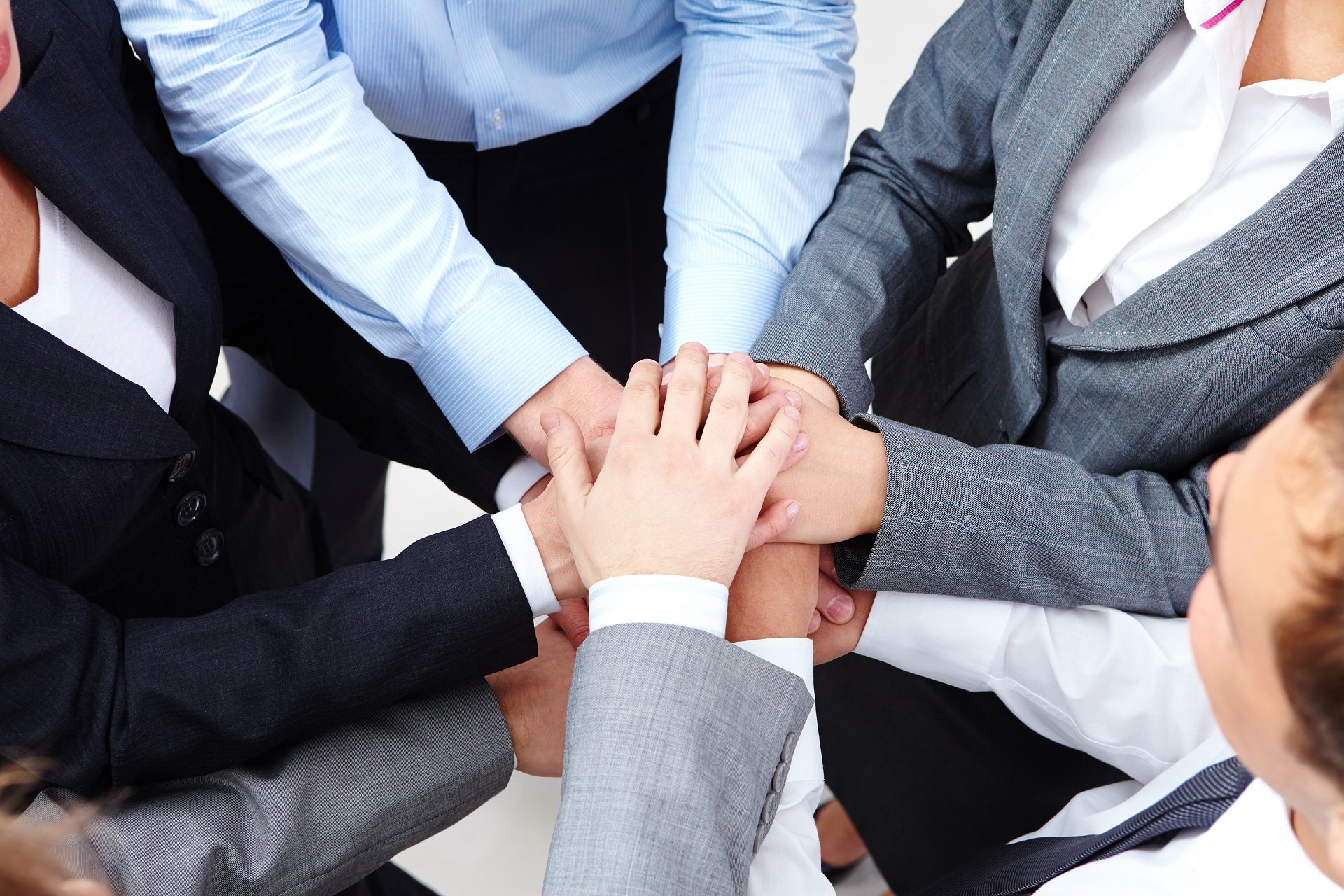 Group of people putting their hands in a circle