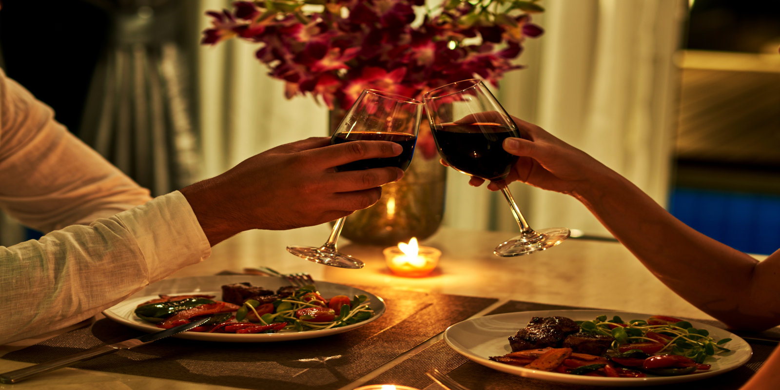 a couple clinking wine glasses during a date night in northern virginia