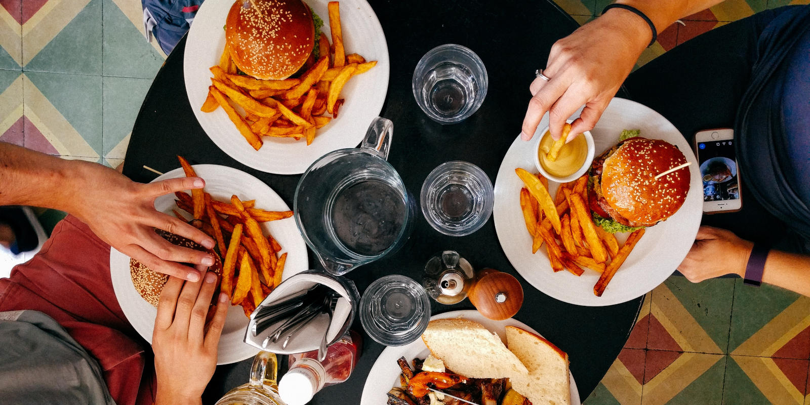 four people eating food on a black wooden table at a Fairfax restaurant